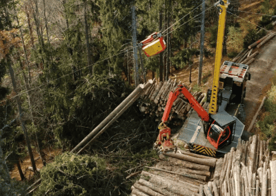 Stromové vedenie sa opravuje v lese pomocou bagra a plošiny.